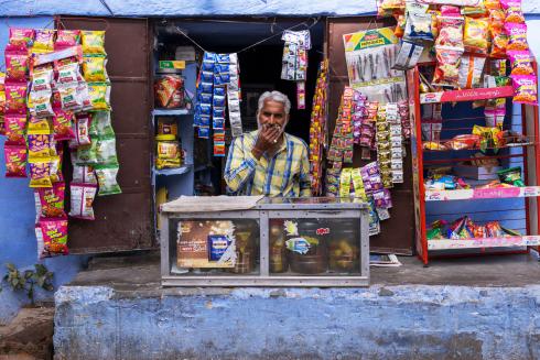 A male Indian vendor waiting at his grocery store