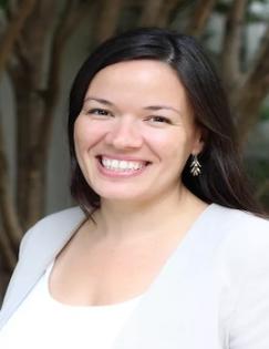 Elizabeth Linos in a white shirt and light grey jacket