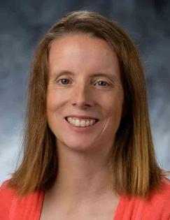 head shot of a woman with shoulder length straight brown hair wearing a red sweater