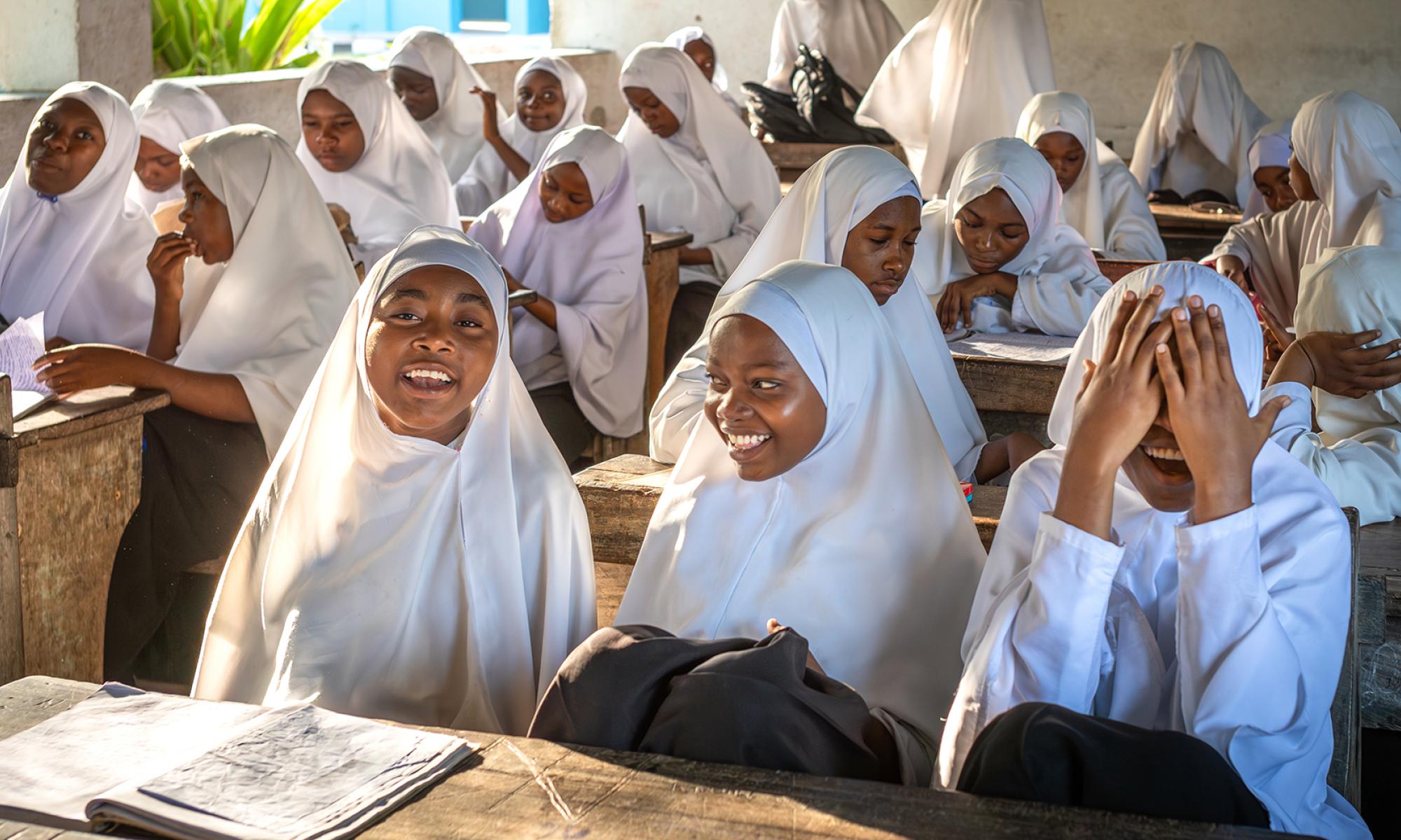 Adolescent students smiling and laughing in a classroom