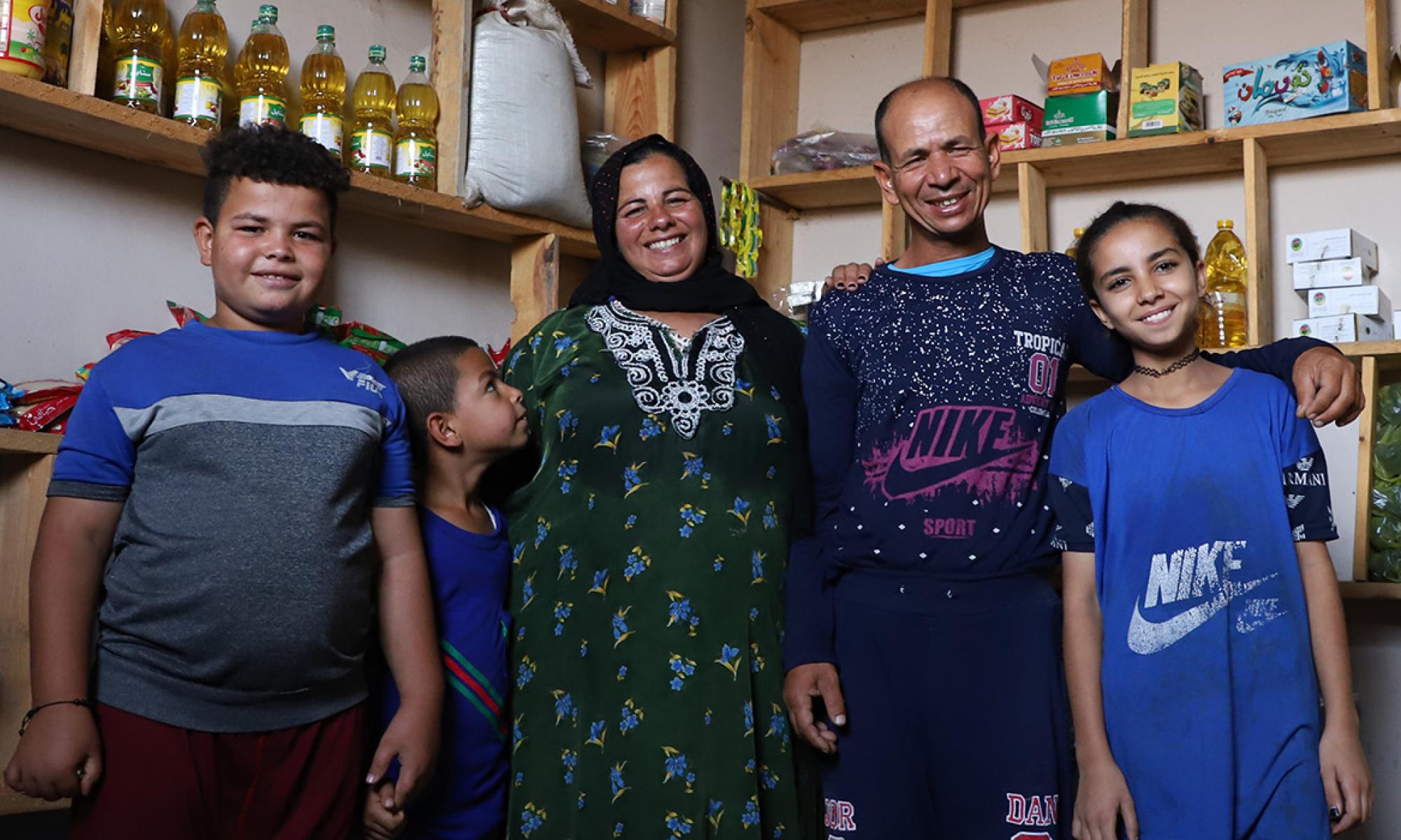 Family standing in front of shelves in their shop