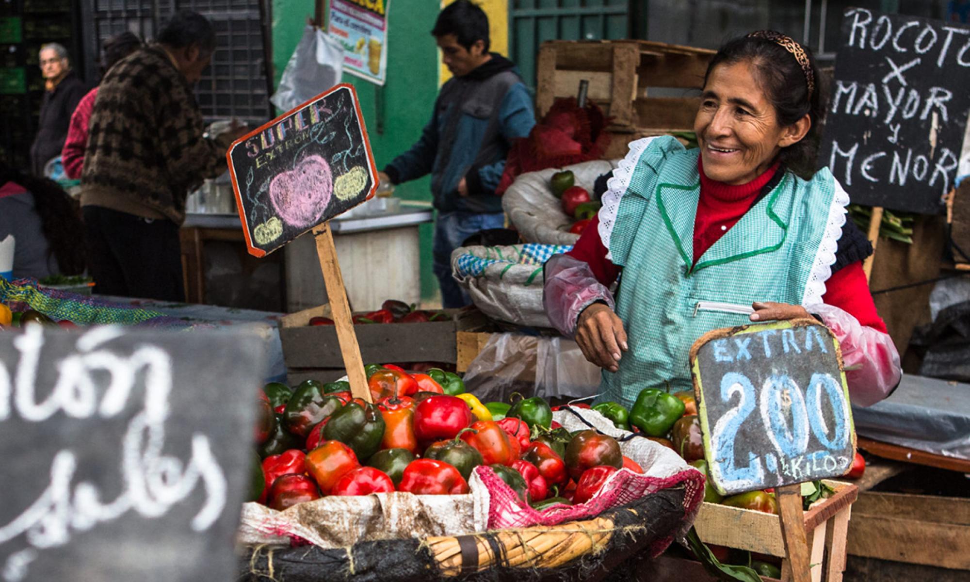 Woman smiling in front of her vegetable stand