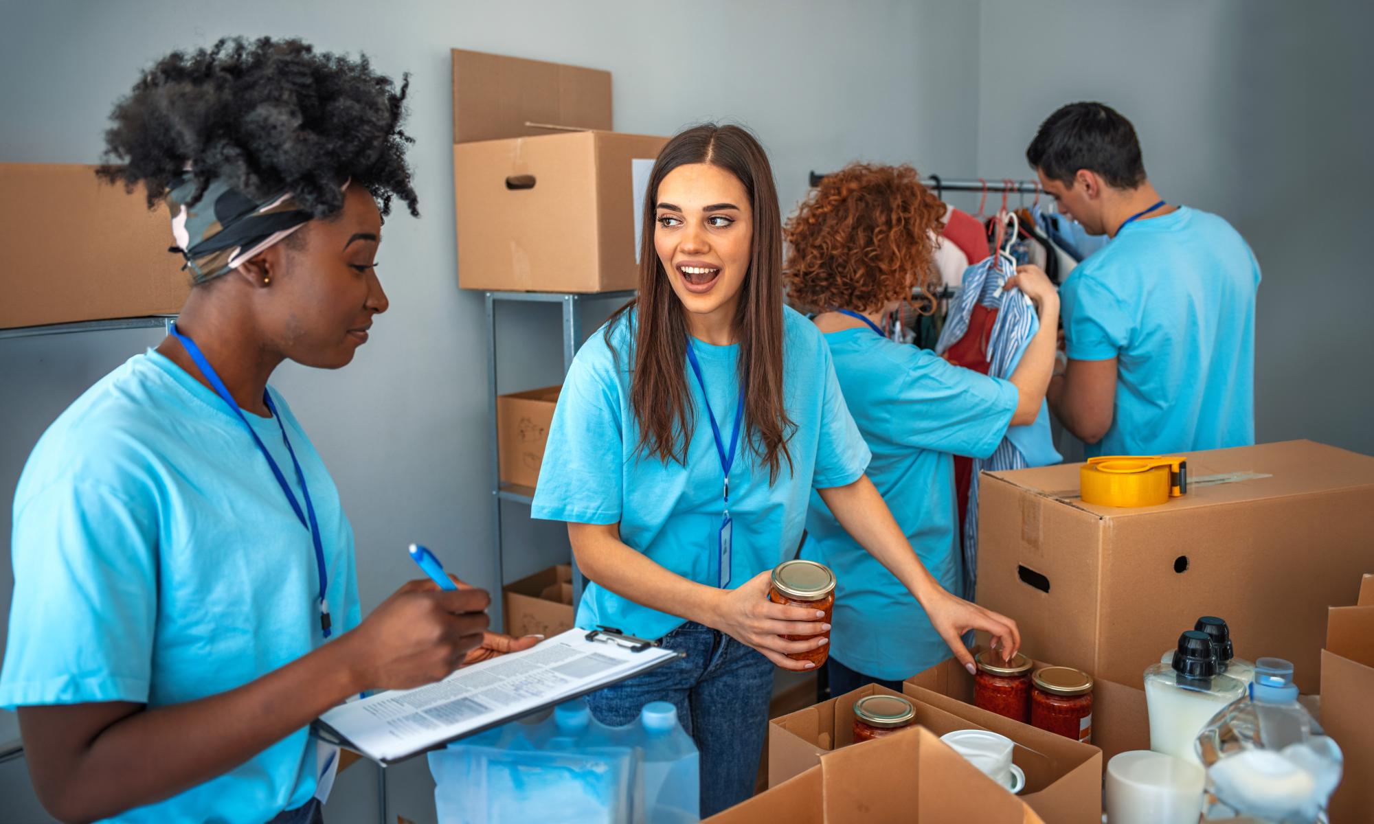 Three teenage girls work together to place cans in a boxes