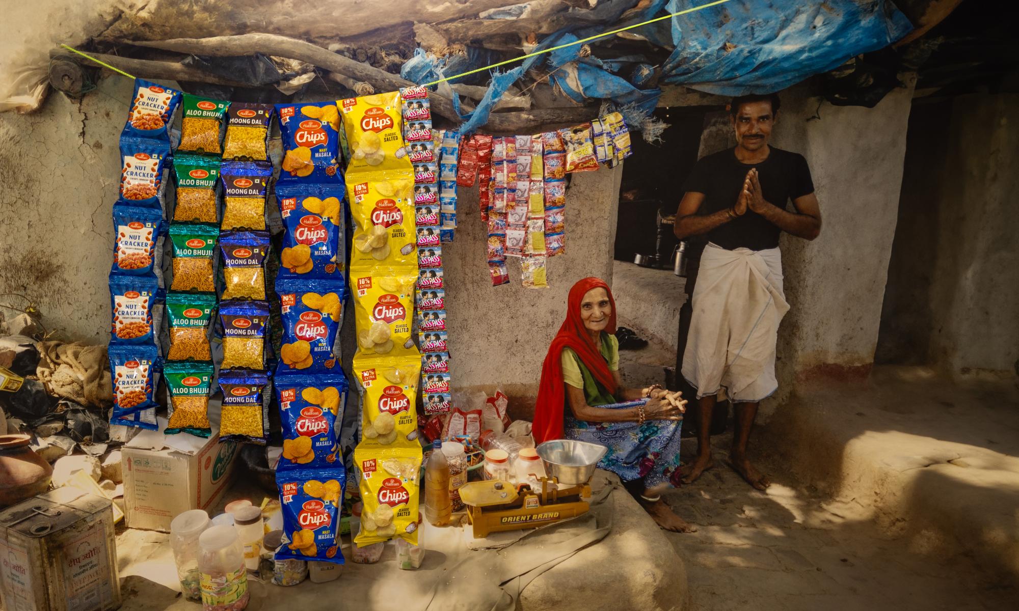 A woman sitting next to a standing man in her shop