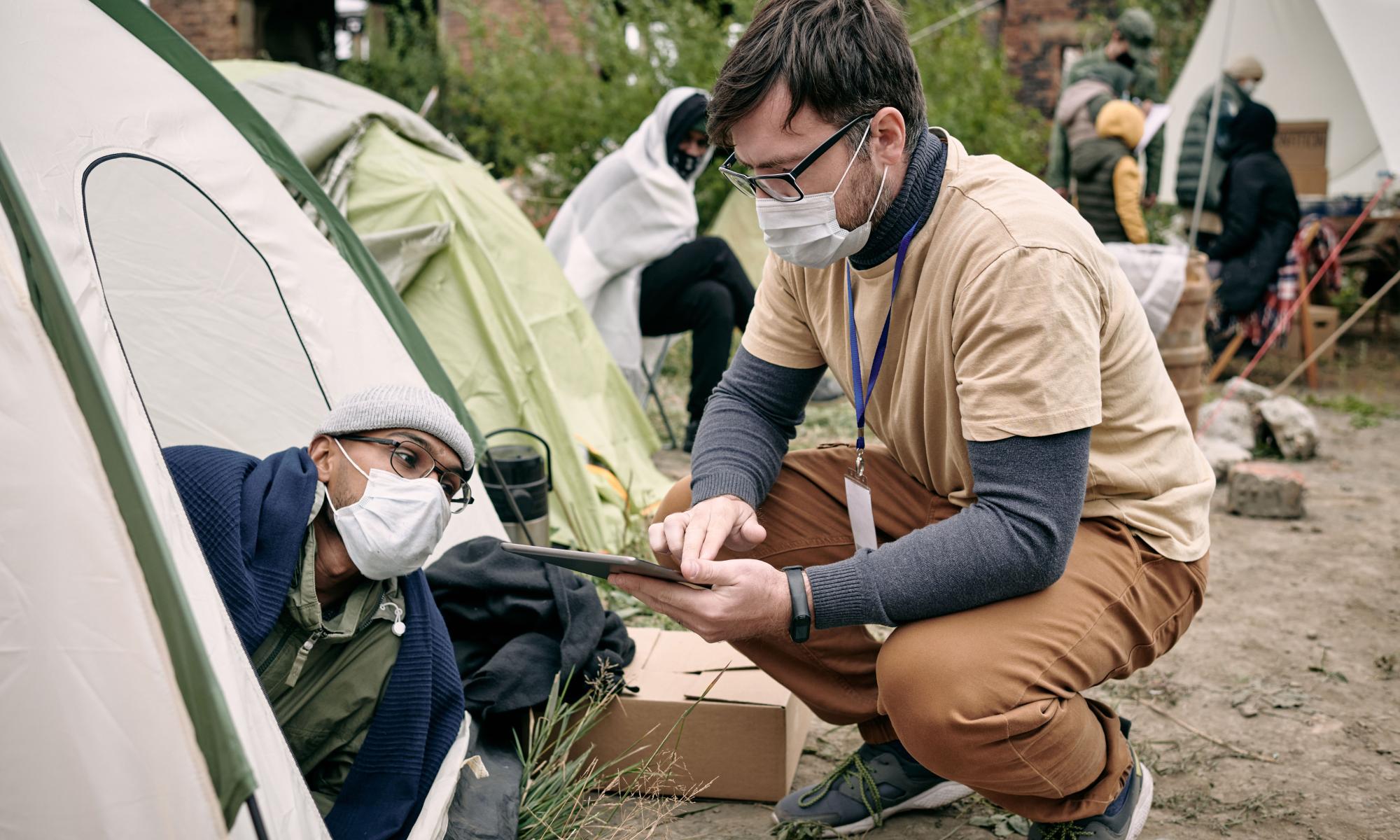 Volunteer asks man in tent questions