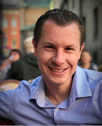 Headshot of Kyle Emerick in blue shirt.