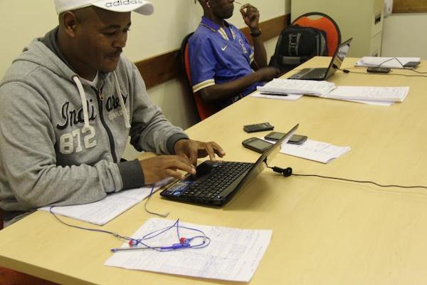 Two enumerators in South Africa conduct phone surveys.