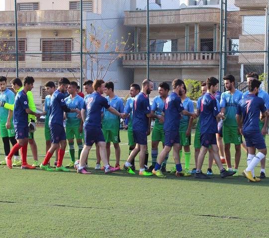 Mixed Christian and Muslim amateur soccer league groups greet each other before a game.