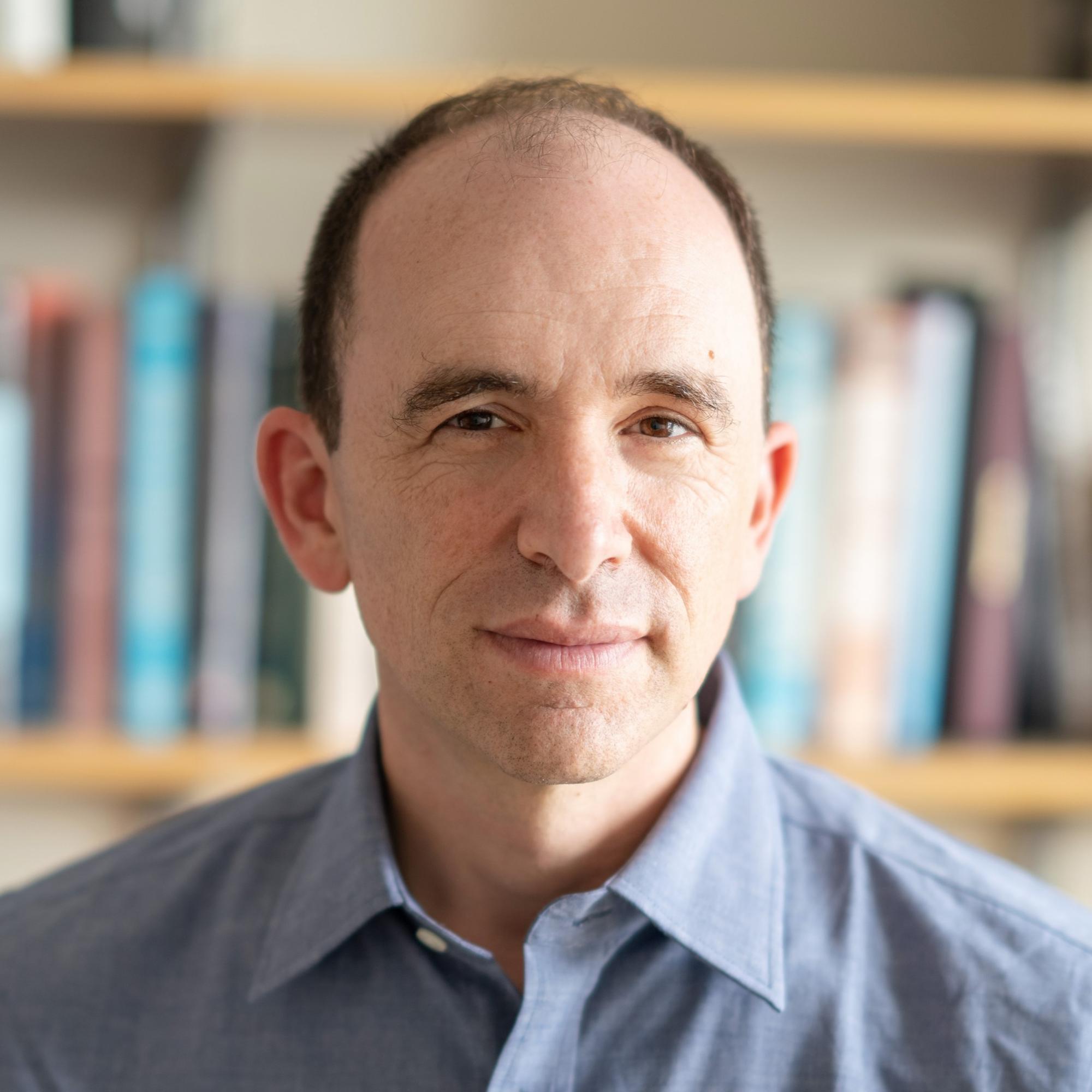 The photo shows Ben Olken in a button-up shirt
