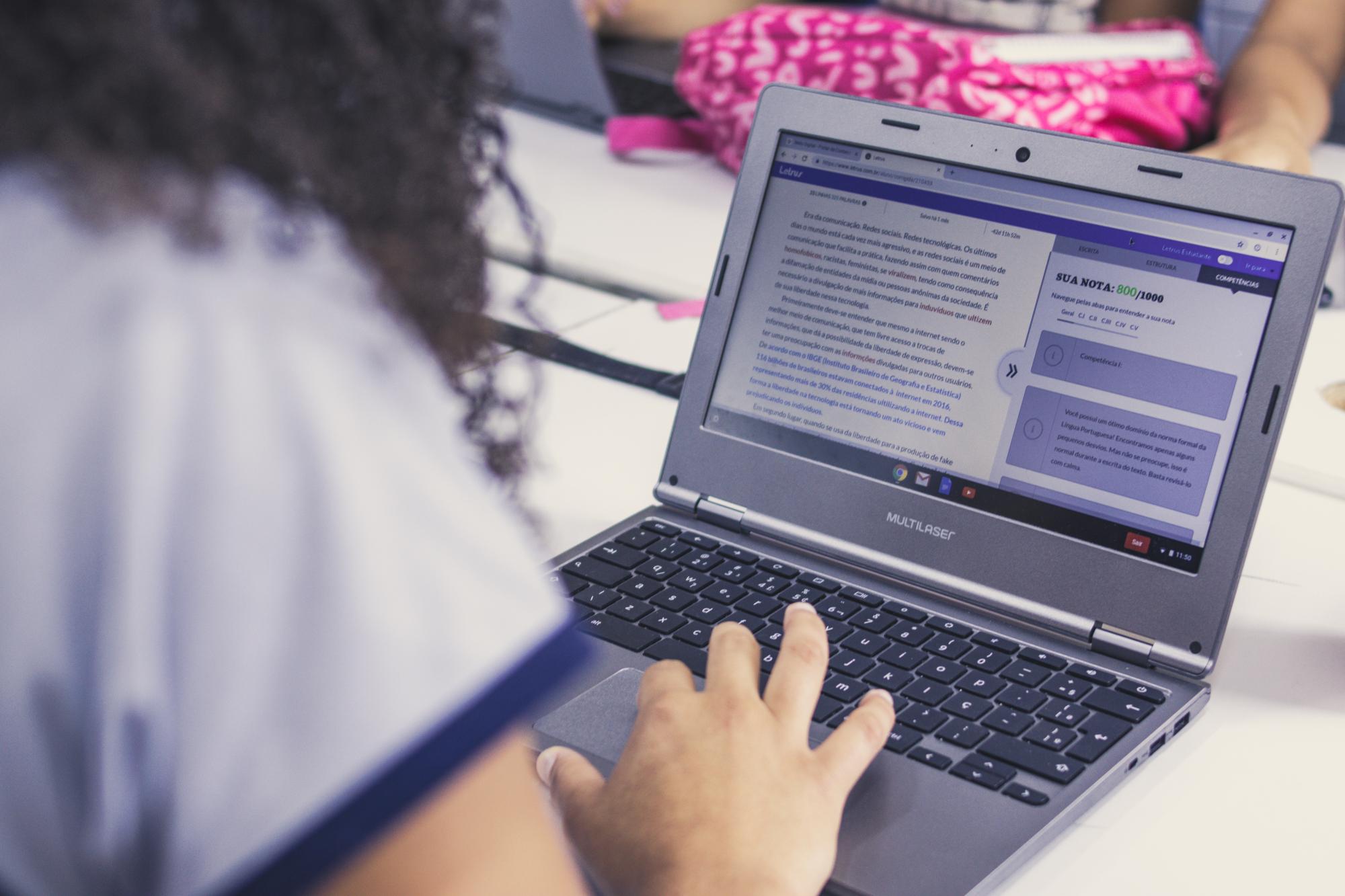 A student looks at a screen, featuring essay feedback given by the Letrus platform.