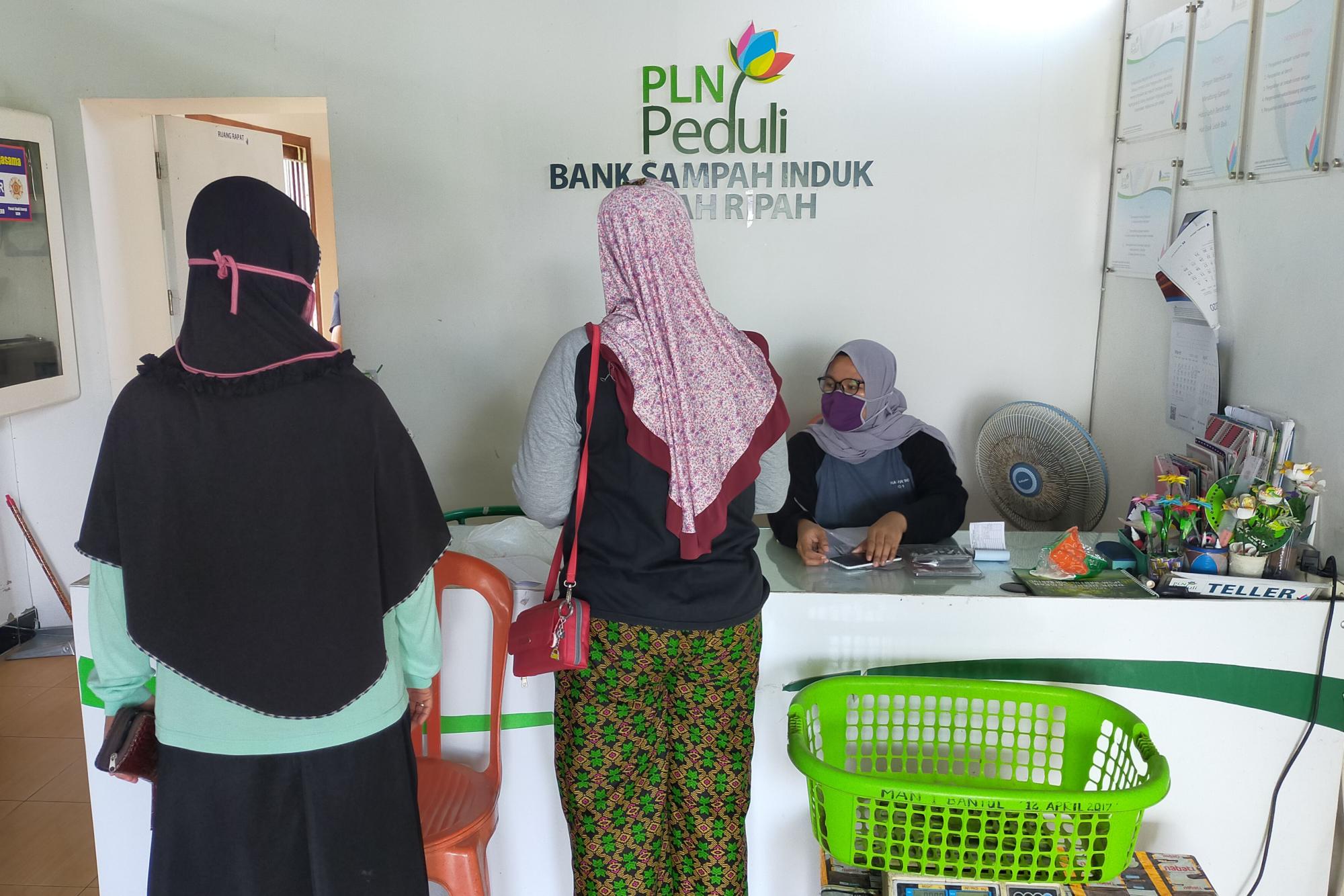 Two women standing in front of a bank teller
