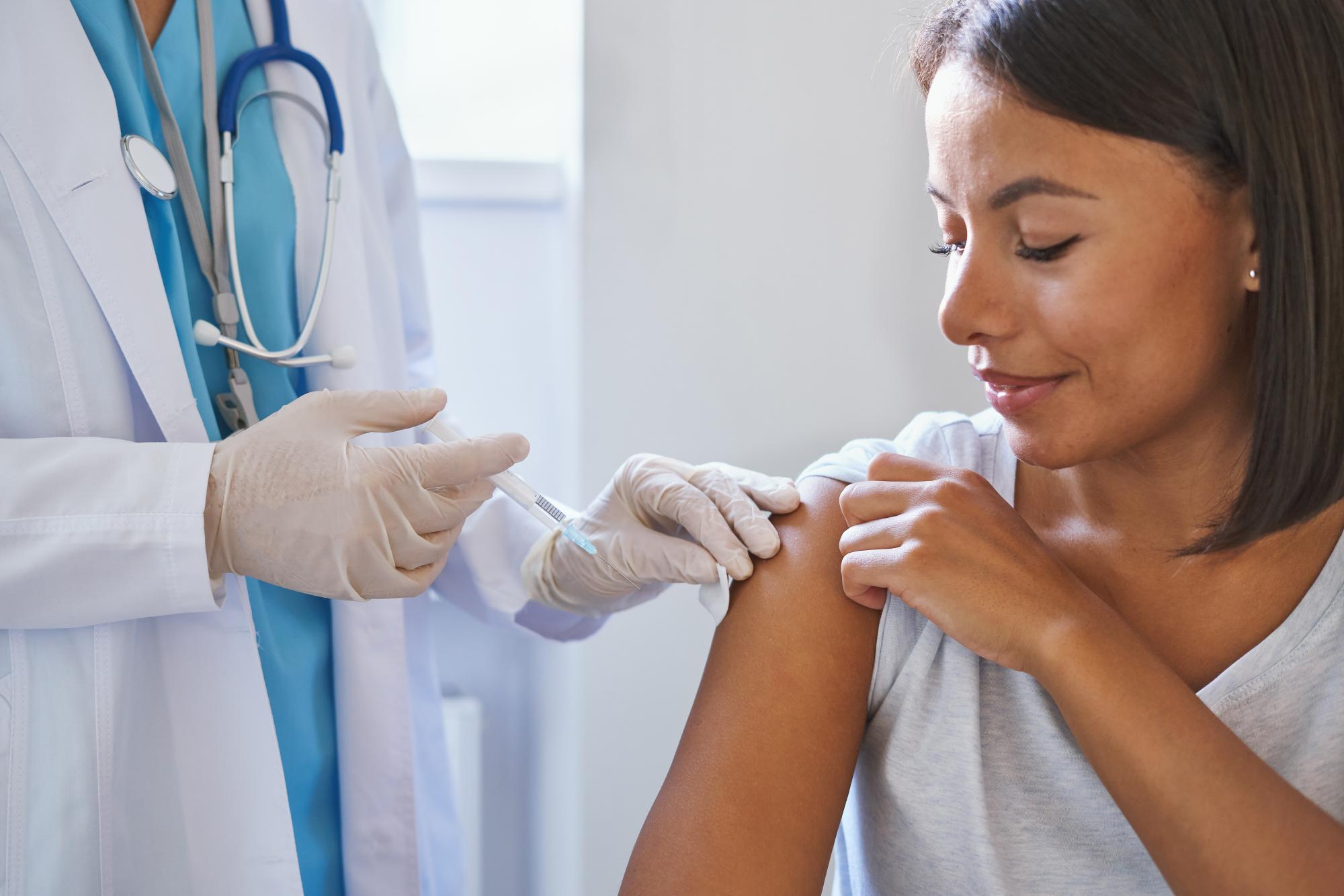 Woman smiling while receiving a vaccine