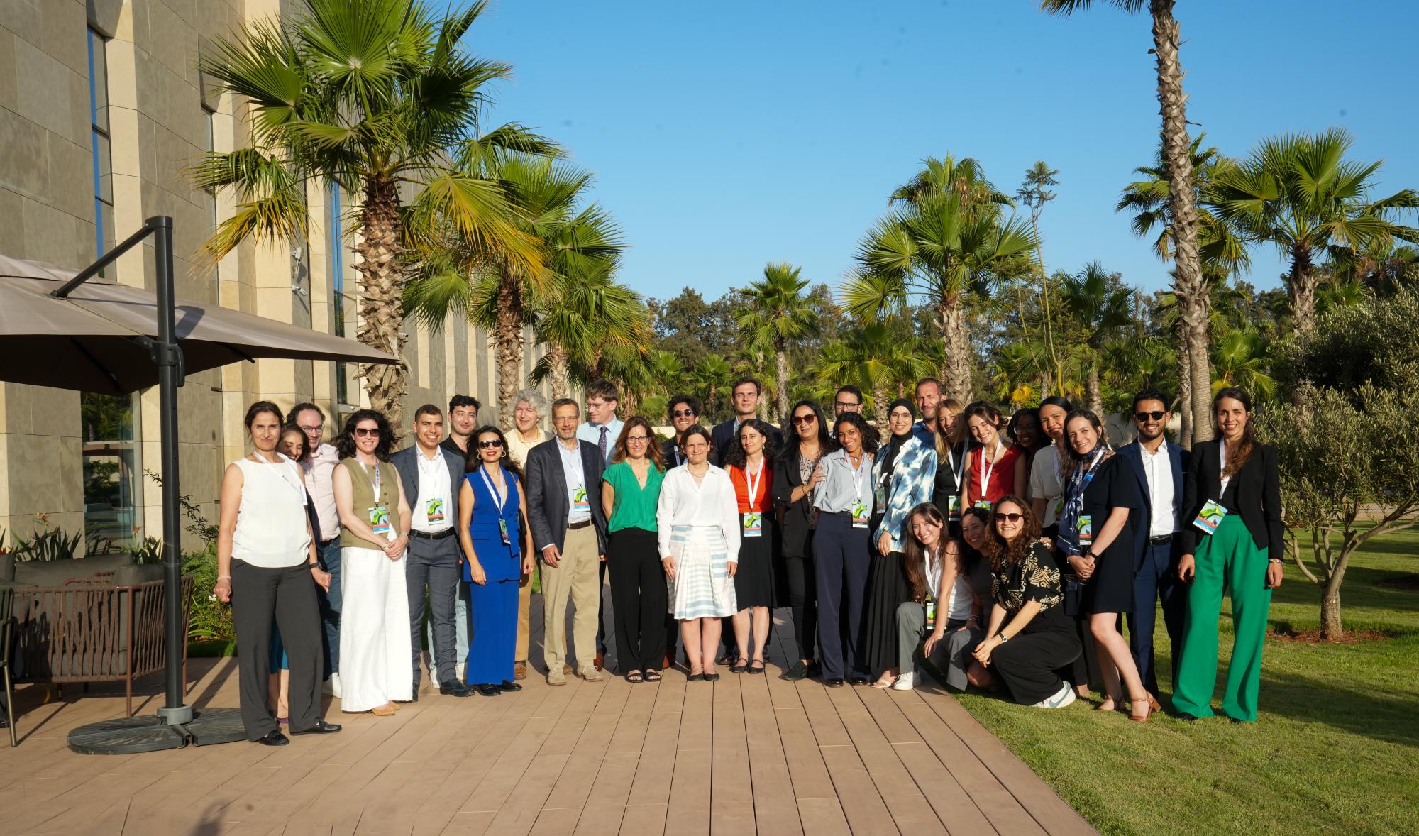 A group of colleagues and researchers posing for a picture in the sunshine.