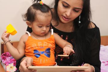 Mother teaching a block game to a young child.