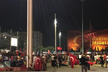 Turkish citizens gather at night in Taksim square with Turkish flags