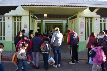 Parents and children standing outside a school.