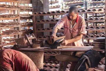 Man operating in pottery business through loan in Egypt.