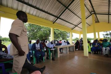 Angled view of community members deliberating on electoral strategies in Benin