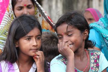 Two girls are pictured sitting side by side. 