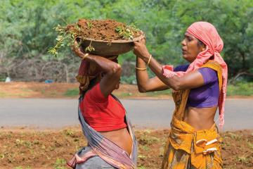 Women in India moving receptacles of dirt.