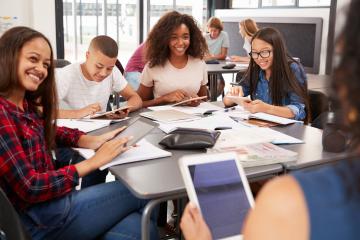 Students work on schoolwork together around a table