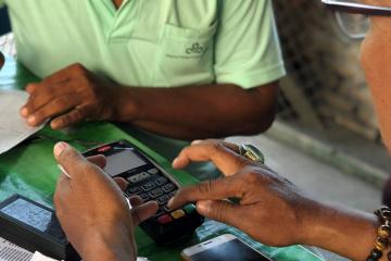 A close-up picture of two hands operating a card reader