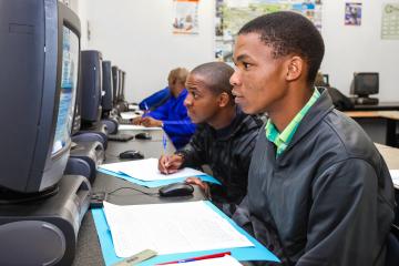 Two South African youths engaging in online skills training 