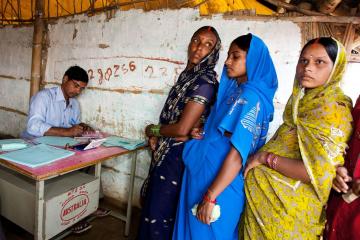 Women standing in line in front of a desk