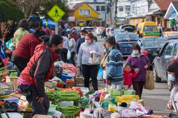 People walk through an outdoor market in Chile.