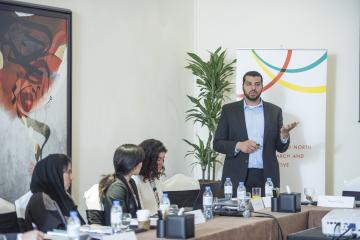 Adam Osman presents in front of a J-PAL MENA banner