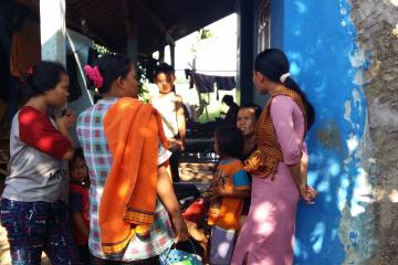 A group of women and children stand in a group, talking