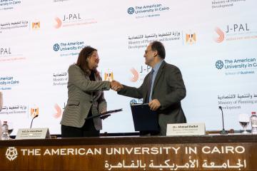 The Minister of Planning and Economic Development shakes hands with the President of the American University in Cairo