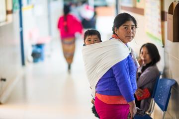 Mujer con hijo en su espalda asiste a hospital