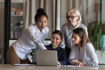 Four women looking at a laptop