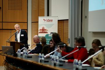 J-PAL affiliate Marc Gurgand speaks at a lectern and looks at a row of panelists.