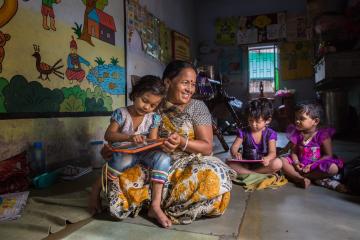 Woman with three children in childcare center in Ahmedabad, Gujarat, India