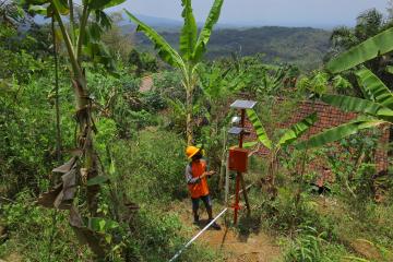 Photo of an officer checking the condition of the solar panel, early warning system, in anticipation of landslides