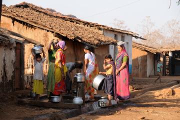  Indian women carry water on their heads in pots from well.