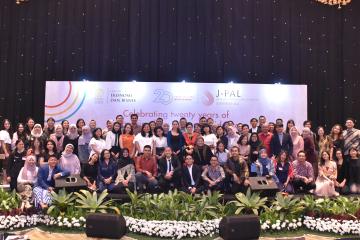 A group of people stand in front of a backdrop.