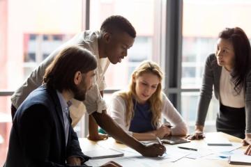 A group of people working together on a round table.