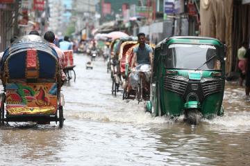 Several rickshaws driving through a flood in Bangladesh