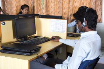 A man in side profile uses a desktop computer